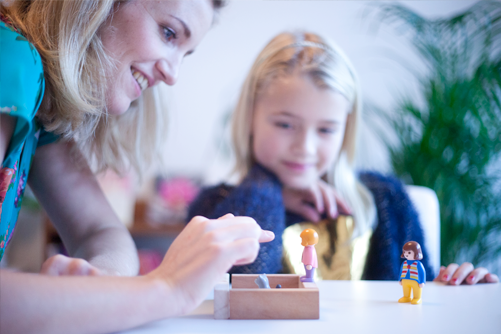 Psycholoog speelt met kind en moeder als onderdeel van diagnostiek